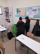 Οι δύο μαθητές βοηθούν στη συγκέντρωση του ανακυκλώσιμου χαρτιού από τις τάξεις.